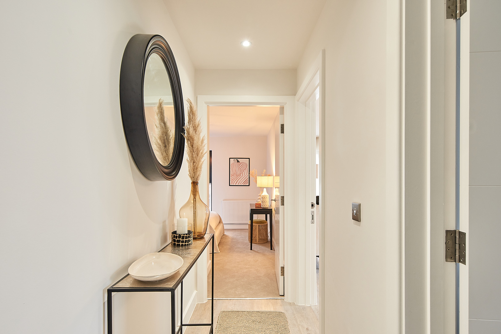 Hallway with console table, mirror, and decorative vases leading to a bedroom. Interior design.